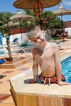 Happy young smiling boy in the pool