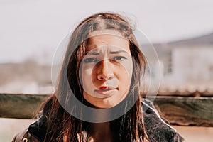 Happy young smiling woman with freckles outdoors portrait. Soft sunny colors. Outdoor close-up portrait of a young