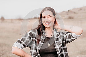 Happy young smiling woman with freckles outdoors portrait. Soft sunny colors. Outdoor close-up portrait of a young