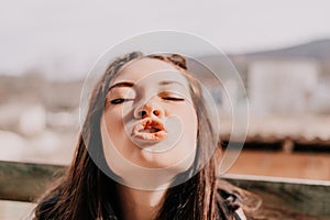 Happy young smiling woman with freckles outdoors portrait. Soft sunny colors. Outdoor close-up portrait of a young