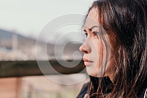 Happy young smiling woman with freckles outdoors portrait. Soft sunny colors. Outdoor close-up portrait of a young