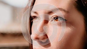 Happy young smiling woman with freckles outdoors portrait. Soft sunny colors. Outdoor close-up portrait of a young