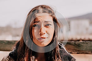 Happy young smiling woman with freckles outdoors portrait. Soft sunny colors. Outdoor close-up portrait of a young