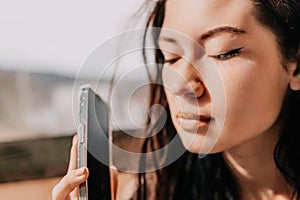 Happy young smiling woman with freckles outdoors portrait. Soft sunny colors. Outdoor close-up portrait of a young