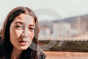 Happy young smiling woman with freckles outdoors portrait. Soft sunny colors. Outdoor close-up portrait of a young