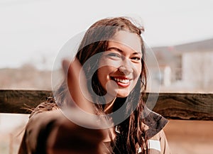 Happy young smiling woman with freckles outdoors portrait. Soft sunny colors. Outdoor close-up portrait of a young