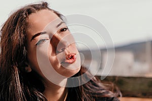 Happy young smiling woman with freckles outdoors portrait. Soft sunny colors. Outdoor close-up portrait of a young