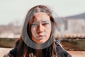 Happy young smiling woman with freckles outdoors portrait. Soft sunny colors. Outdoor close-up portrait of a young