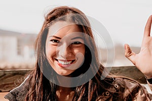 Happy young smiling woman with freckles outdoors portrait. Soft sunny colors. Outdoor close-up portrait of a young