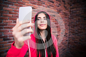 Happy young sportive woman looking on smartphone