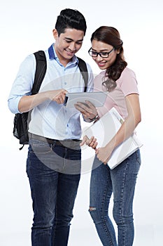 Happy young student couple using tablet computer, isolated on white background