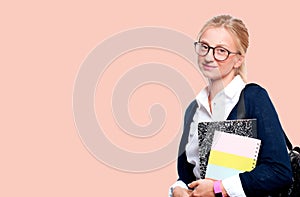 Happy young student girl holding books on pink background. Back to school