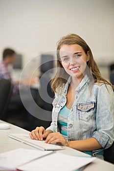 Happy young student studying in the computer room