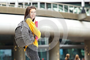 Happy young student walking on city campus