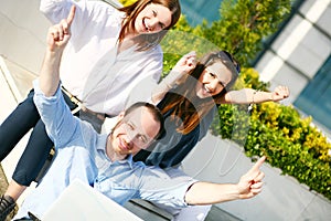Happy young students with hands up