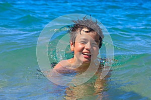 Happy young swims in the sea