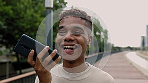 Happy young teenage boy using mobile phone outdoor