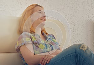 Happy young teenage girl lughing while resting on sofa