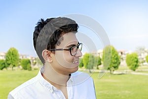 Happy young teenager with eye-wear in garden.