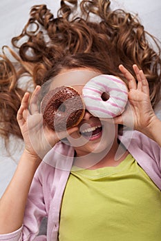 Happy young teenager girl with a donut goggle laughing