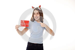 Happy young teenager girl in white t-shirt and santa claus red hat holds gift certificate isolated on white background. People