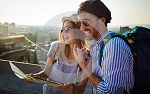Happy tourist couple, friends sightseeing city with map. Travel people vacation concept
