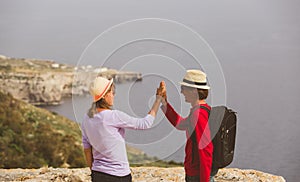 Happy young tourist couple hiking in mountains