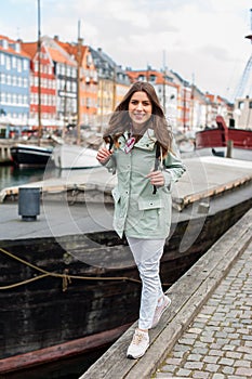 Happy young tourist woman with backpack at Copenhagen