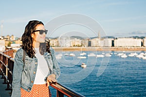 Happy young tourist woman enjoying the view of San Sebastian bay in Spain photo