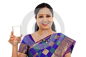 Happy young traditional woman drinking glass of water