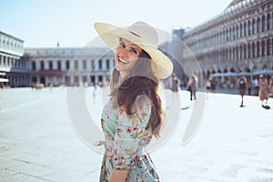 Happy young traveller woman in floral dress sightseeing photo