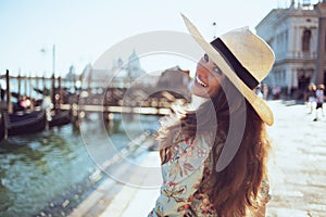 Happy young traveller woman in floral dress having excursion