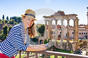 Happy young traveller woman in Rome, Italy viewing photos