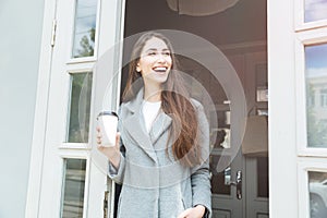 Happy young trendy woman drinking take away coffee