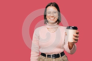 Happy young trendy woman smiling and showing paper cup of coffee. Eco Cup