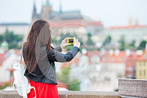 Happy young urban woman in european city on the famous bridge. Caucasian tourist walking in Prague, Czech Republic