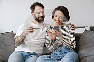 Happy young white couple looking at mobile phone