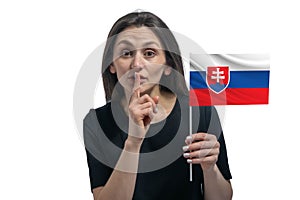 Happy young white woman holding flag of Slovakia and holds a finger to her lips isolated on a white background