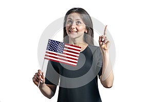 Happy young white woman holding flag of United States and points thumbs up isolated on a white background