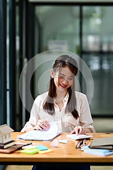 Happy woman accountant checking financial reports at office.