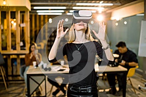 Happy young woman adjusting her virtual reality headset and excited playing video game in VR device while standing at