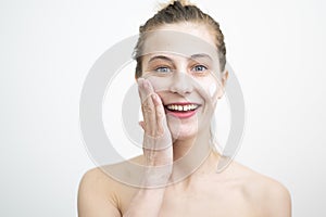 Happy Young Woman Applying Cream on Her Face