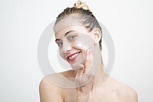 Happy Young Woman Applying Cream on Her Face Studio Shot on White Background
