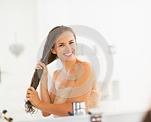 Šťastný mladá žena použitie vlasy v kúpeľňa 