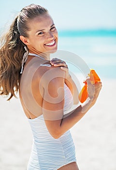 Feliz mujer joven el uso el sol bloquear sobre el Playa 