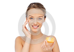 Happy young woman appying cream to her face