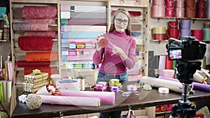 Happy young woman as florist in a flower shop designs and creates arrangements of flowers in wreaths, bouquets, vases