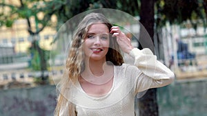 Happy young woman in autumn city park is laughing for joy