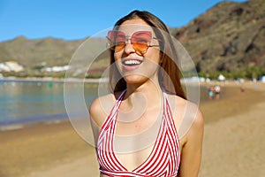 Happy young woman on the beach. Outdoor fashion portrait of lady enjoying her vacation on hot tropical island