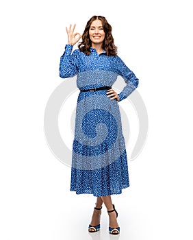 happy young woman in blue dress showing ok gesture
